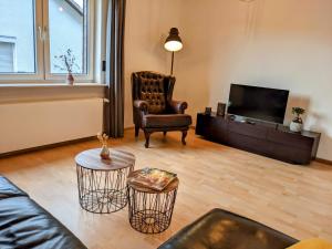 a living room with a couch and a chair and a television at Ferienwohnung 50m2 in Hilchenbach