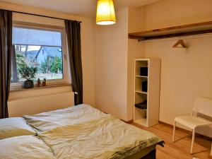 a bedroom with a bed and a window and a chair at Ferienwohnung 50m2 in Hilchenbach