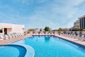 ein Schwimmbad mit Liegestühlen und ein Hotel in der Unterkunft Crowne Plaza Riyadh Palace by IHG in Riad