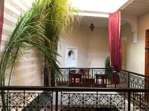 a balcony with tables and chairs and plants at riad rose eternelle in Marrakesh