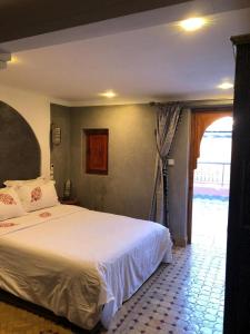 Un dormitorio con una gran cama blanca y una ventana en riad rose eternelle en Marrakech