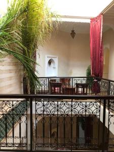 balcón con mesa, sillas y plantas en riad rose eternelle en Marrakech