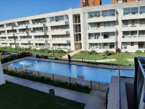 une grande piscine en face d'un bâtiment dans l'établissement Hermoso Departamento familiar en condominio, à El Tabo