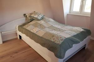 um quarto com uma cama com uma colcha em Kranichhöhe em Hohwacht
