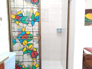 y baño con ducha y vidriera. en Etnias Hotel tematico, en Quibdó
