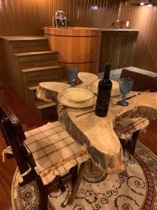 a wooden table with a bottle of wine on top of it at Cabana Retrô com lareira e Ofurô em Monte Verde in Monte Verde +35 photos