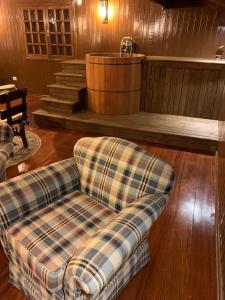 a living room with a couch and a barrel at Cabana Retrô com lareira e Ofurô em Monte Verde in Monte Verde