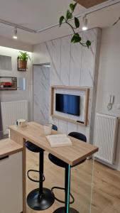 a room with a table with chairs and a tv at Magic House Apartament Proszowska 58 in Bochnia