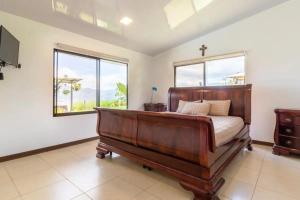 1 dormitorio con 1 cama y 2 ventanas en Rancho Bellavista, unique views, pool & wifi, en Turrialba