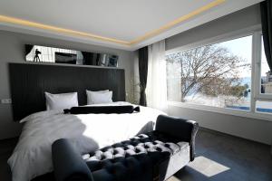 a bedroom with a bed and a couch and a window at Via Çırağan Hotel in Istanbul