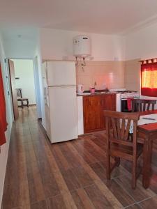 a kitchen with a white refrigerator and a table at CABAÑA LA HERRADURA 14 in San Roque