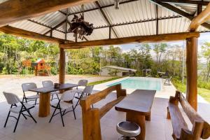 a patio with a table and chairs and a swimming pool at Rancho Bellavista, Unique views, Pool and WiFI! in Turrialba
