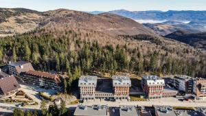 uma vista aérea de um edifício com montanhas ao fundo em Bellevue Bjelasnica em Bjelašnica