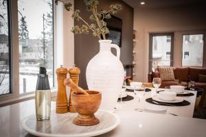 a table with a large white vase on top of it at ✦Chic Haven✦3BR Near DT & WEM, King Bed, Trails, Fast Wifi, Sleeps 6! in Edmonton