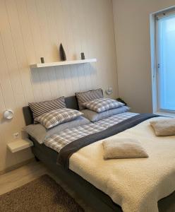 un grande letto con cuscini sopra in una stanza di Bagoly a Fertőrákos