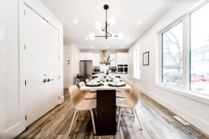 a white dining room with a table and chairs at ✦Chic Haven✦3BR Near DT & WEM, King Bed, Trails, Fast Wifi, Sleeps 6! in Edmonton