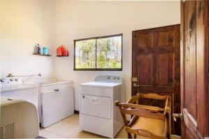 a laundry room with a washer and dryer and a window at Rancho Bellavista, unique views, pool & wifi in Turrialba