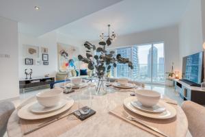 a dining room with a glass table with chairs at Maison Privee - Aesthetic Apt with Stunning View in Luxurious Building in Dubai