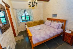 - une chambre avec un lit doté de draps violets et une fenêtre dans l'établissement SAUNTON GRANGE 7 Bedrooms, à Braunton