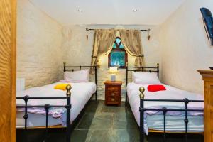 two twin beds in a room with a window at SAUNTON GRANGE 7 Bedrooms in Braunton