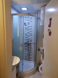uma casa de banho com um chuveiro, um lavatório e um WC. em MR. O Apartments Kopaonik em Kopaonik