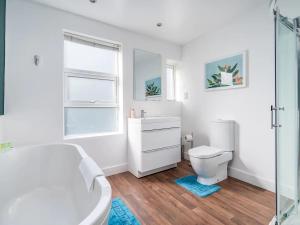 une salle de bains blanche avec toilettes et lavabo dans l'établissement "FurnishedRentals Direct" WiggenHouse Stylish 3 Bedroom house Sleeps 8 with Free Parking, 2 Bathrooms, near to Watford High Street and Watford Football Stadium, Suitable for visiting Harry Potter Warner Bros Studio and London, à Watford 15 autres photos