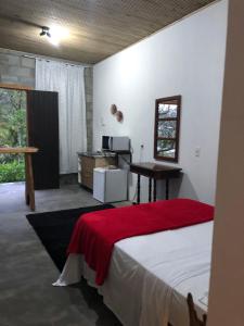 a bedroom with a bed with a desk and a computer at Pousada Rosa Bonita in Praia do Rosa