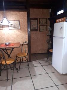 a kitchen with a table and a white refrigerator at Complejito El Pichon in La Paloma