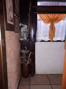 a room with a window with an orange curtain at Complejito El Pichon in La Paloma