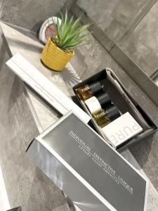 a box of cosmetics on a table with a plant at Brand New SILVER FORGE - Charming Two Bedroom Apartment - City Centre - Lux Apartment in Birmingham