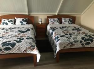 2 nebeneinander sitzende Betten in einem Schlafzimmer in der Unterkunft casa caminho da praia in Porto da Cruz