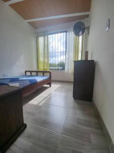 a bedroom with a bed and a large window at CASA DOÑA BLANCA in Guaduas