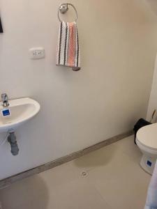 een witte badkamer met een wastafel en een toilet bij CASA DOÑA BLANCA in Guaduas