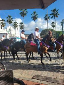 a group of people riding horses on a street at CASA DOÑA BLANCA in Guaduas