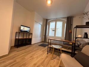 a living room with a couch and a tv at Studio cosy rez-de-chaussée in Foix