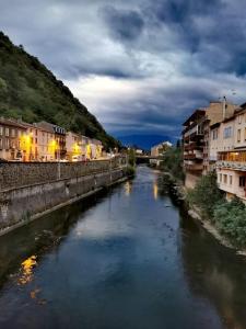 een rivier in een stad 's nachts met gebouwen bij Studio cosy rez-de-chaussée in Foix