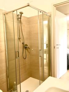 a shower with a glass door in a bathroom at Appartamento con due camere da letto e free park in Verona