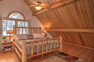 um quarto com uma cama num quarto com paredes de madeira em Rustic Gotham Bay Cabin on Lake Coeur dAlene em Harrison