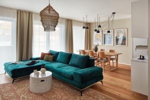 a living room with a green couch and a dining room at Designer Apartments in Smíchov by Prague Days in Prague