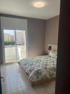 um quarto com uma cama e uma grande janela em Agadir Dreamhouse em Agadir