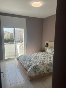 a bedroom with a bed and a large window at Agadir Dreamhouse in Agadir