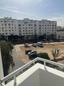 a parking lot with cars parked in front of a large building at Agadir Dreamhouse in Agadir