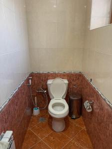 ein Badezimmer mit einem WC und einem Mülleimer in der Unterkunft Family Guest House in Qusar