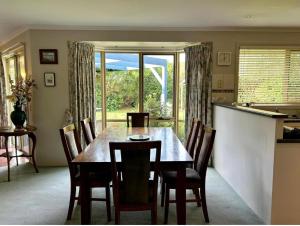 uma sala de jantar com uma mesa e cadeiras e uma janela em Family Holiday Home em Inverloch