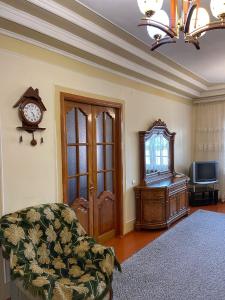 ein Wohnzimmer mit einem Sofa und einer Uhr an der Wand in der Unterkunft Family Guest House in Qusar