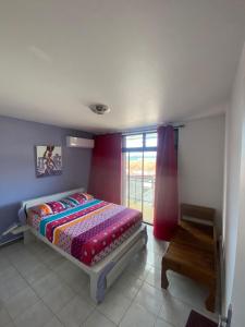 a bedroom with a bed and a window at Grand appartement composé de 2 terrasses avec vue sur mer in Les Trois-Îlets