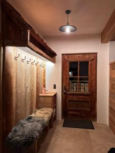 バーワングにあるChalet Schwarzの毛皮ベンチと木製のドアが備わる客室です。