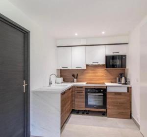 Montmin的住宿－STUDIO LA TOURNETTE，厨房配有白色的柜台和木制橱柜。