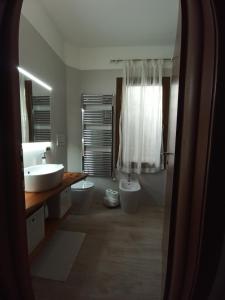 ein Badezimmer mit 2 WCs, einem Waschbecken und einer Badewanne in der Unterkunft Angolo di pace a pochi passi dal centro e dal mare in Lido di Venezia