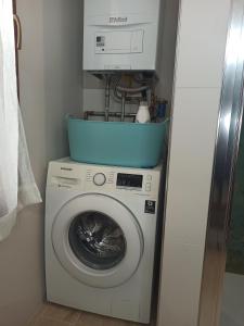 a washing machine with a blue bucket on top of it at Angolo di pace a pochi passi dal centro e dal mare in Venice-Lido